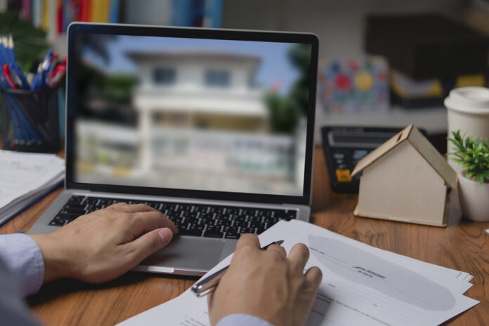 Man using laptop computer to search for real estate rental house or residential condo by internet