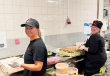 Glada miner i fabriken för smörgåstårtor